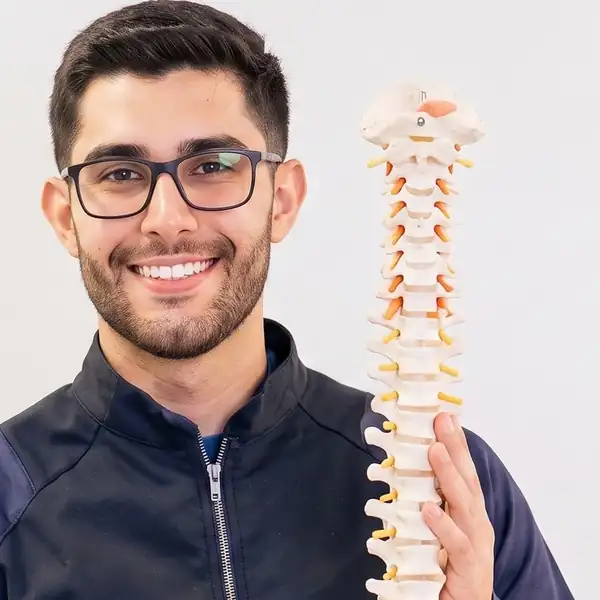 Retrato do Dr. Jean Chagas, fisioterapeuta em Foz do Iguaçu, com um modelo anatômico da coluna vertebral